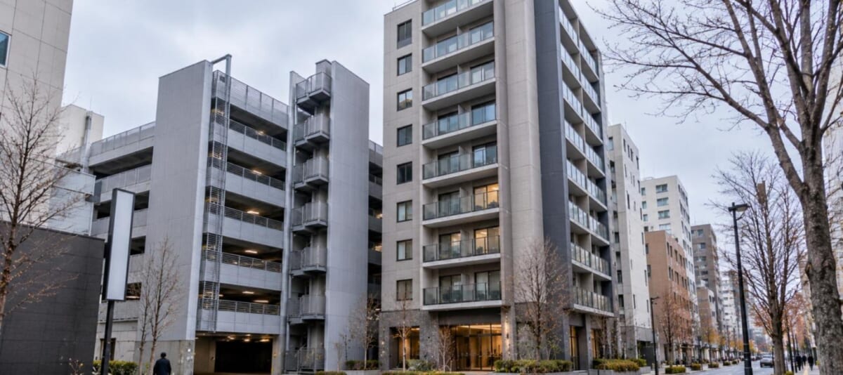 立体駐車場と隣り合う都心の中層マンション(晩秋の曇天)